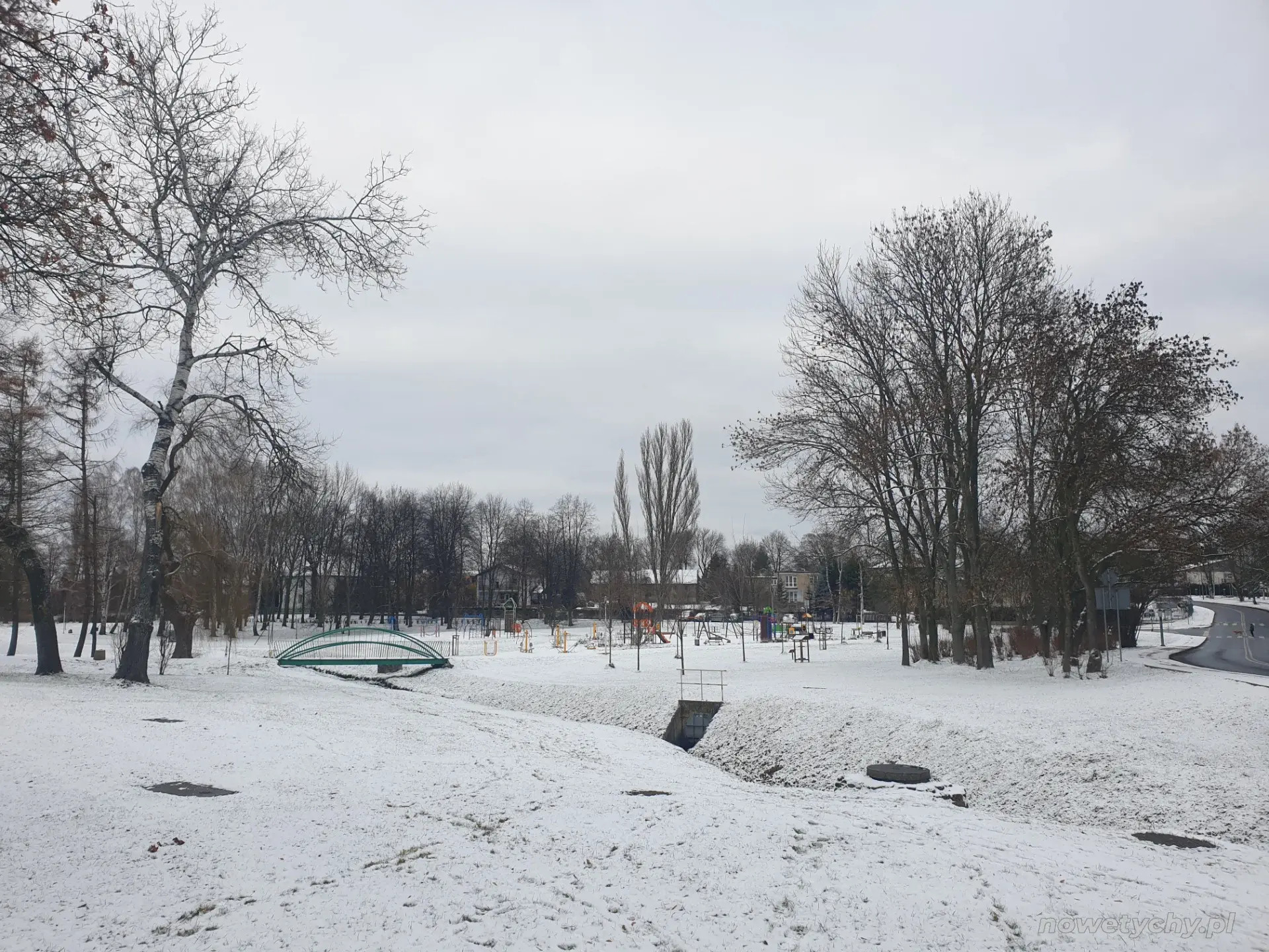 W tle siłownia plenerowa oraz plac zabaw
