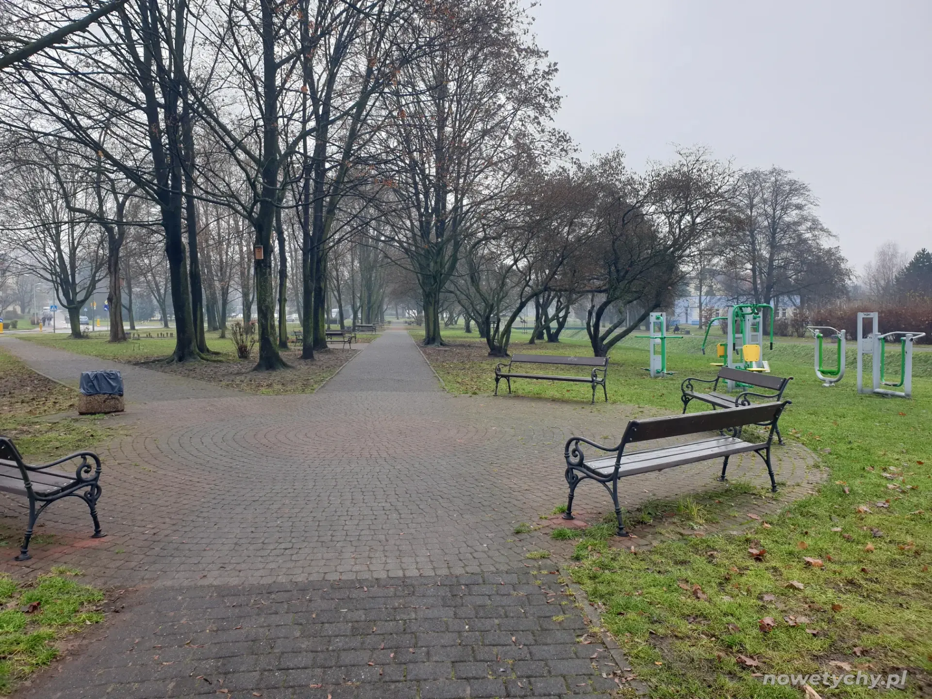 Widok na ławki oraz plenerową siłownię po prawej stronie