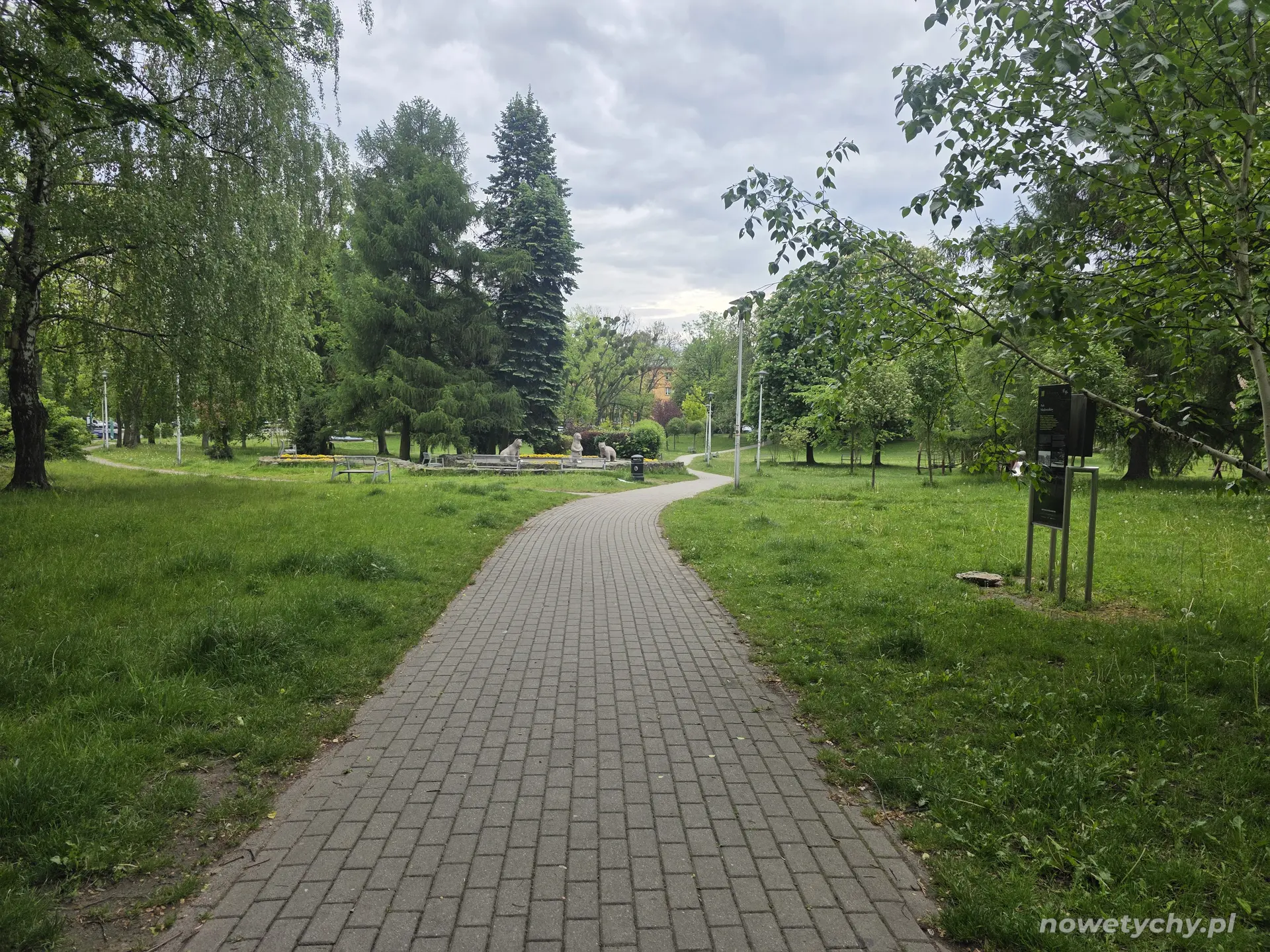 Aleja prowadząca do Niedźwiadk&oacute;w, po prawej stronie tablica informacyjna
