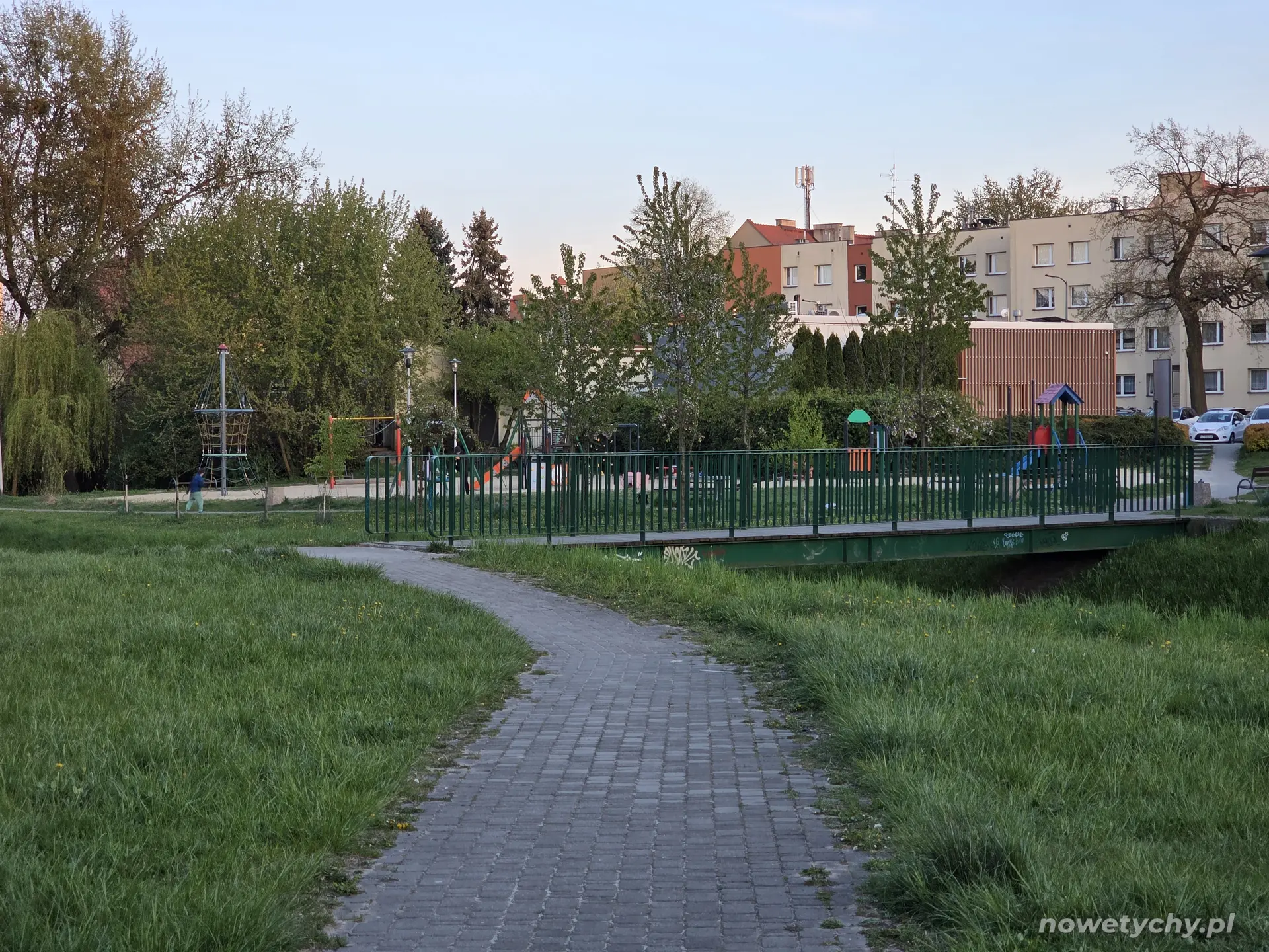 Widoczny plac zabaw za mostkiem